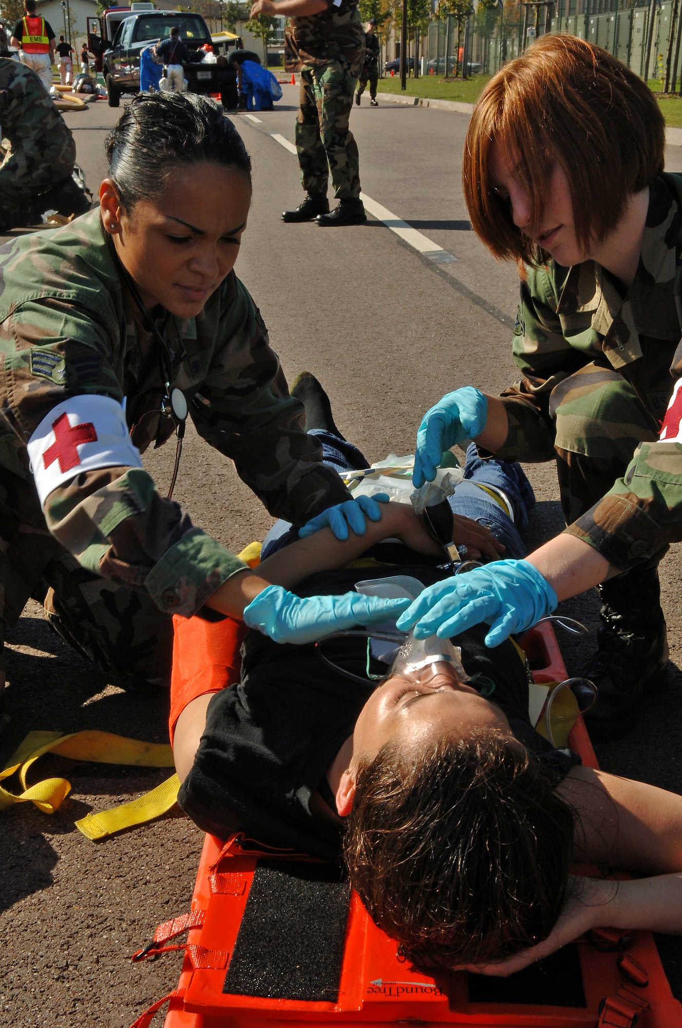 Senior Airman Glenys Cochran (left) and Airman 1st Class Alisha Hicks, 435th Aerospace Medicine Squadron, provide oxygen to Senior Airman Jennifer House during a major accident response exercise on Ramstein Air Base, Germany, Sept. 22. The exercise was based on the collision of two trucks. One truck was carrying ammonia and the other was carrying radiological waste. This exercise tested the procedures of medical, fire, and law enforcement squadrons stationed at Ramstein as well as organization from the German community. (U.S. Air Force photo/Airman 1st Class Marc I. Lane)