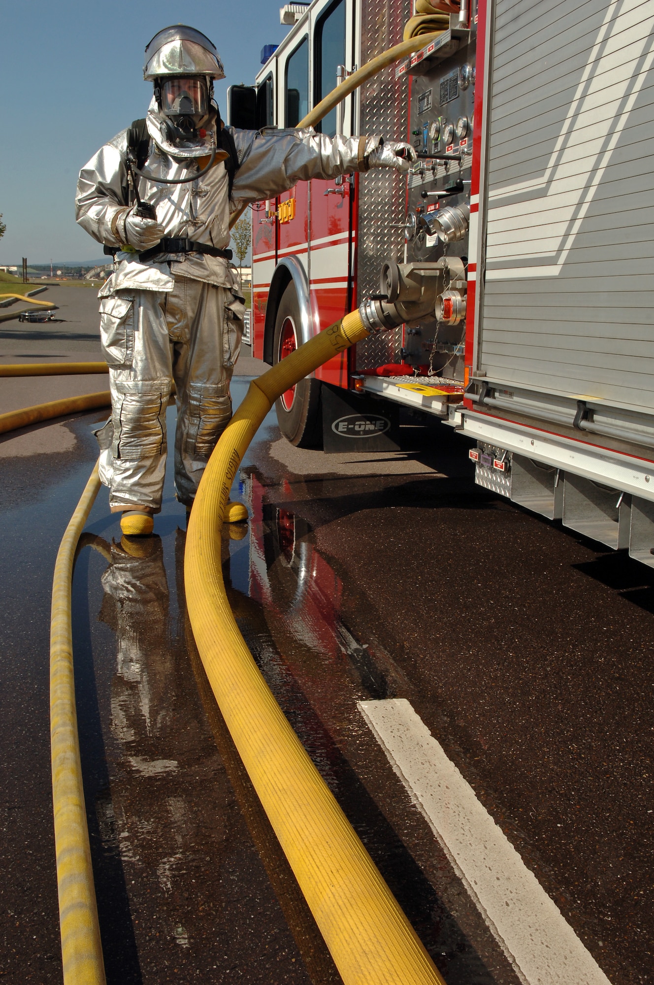 Michael Luba, 435th Civil Engineer Squadron, Fire Fighter, checks the water pressure of multiple fire hoses during a major accident response exercise on Ramstein Air Base, Germany, Sept. 22. The exercise was based on the collision of two trucks. One truck was carrying ammonia and the other was carrying radiological waste. This exercise tested the procedures of medical, fire, and law enforcement squadrons stationed at Ramstein as well as organization from the German community. (U.S. Air Force photo/Airman 1st Class Marc I. Lane)