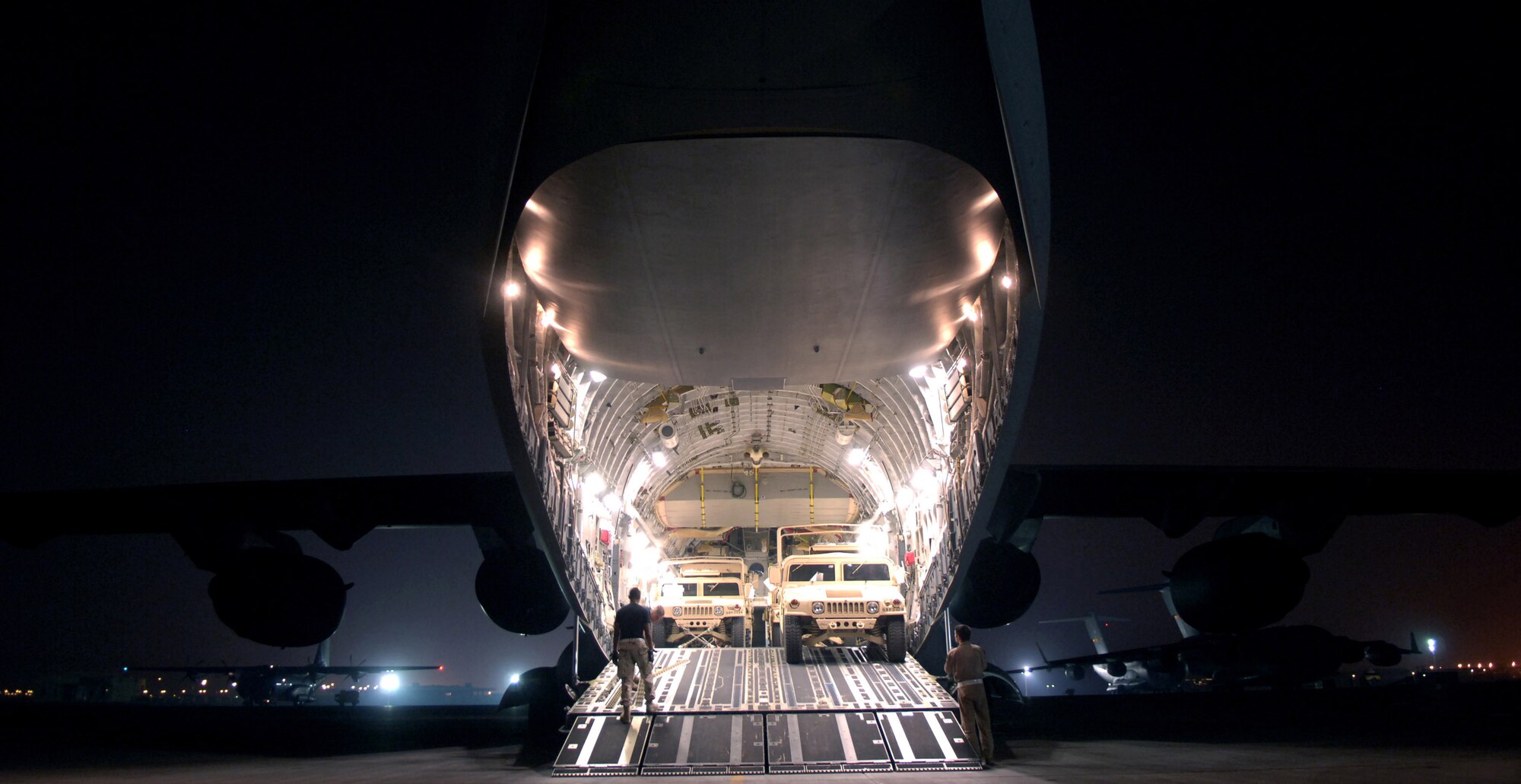 Airmen load humvees into a C-17 Globemaster III at a base in Southwest Asia.  Globemasters provide intra-theater heavy airlift support to help sustain operations throughout Afghanistan, Iraq and the Horn of Africa.  (U.S. Air Force photo/Staff Sgt. Brian Ferguson)