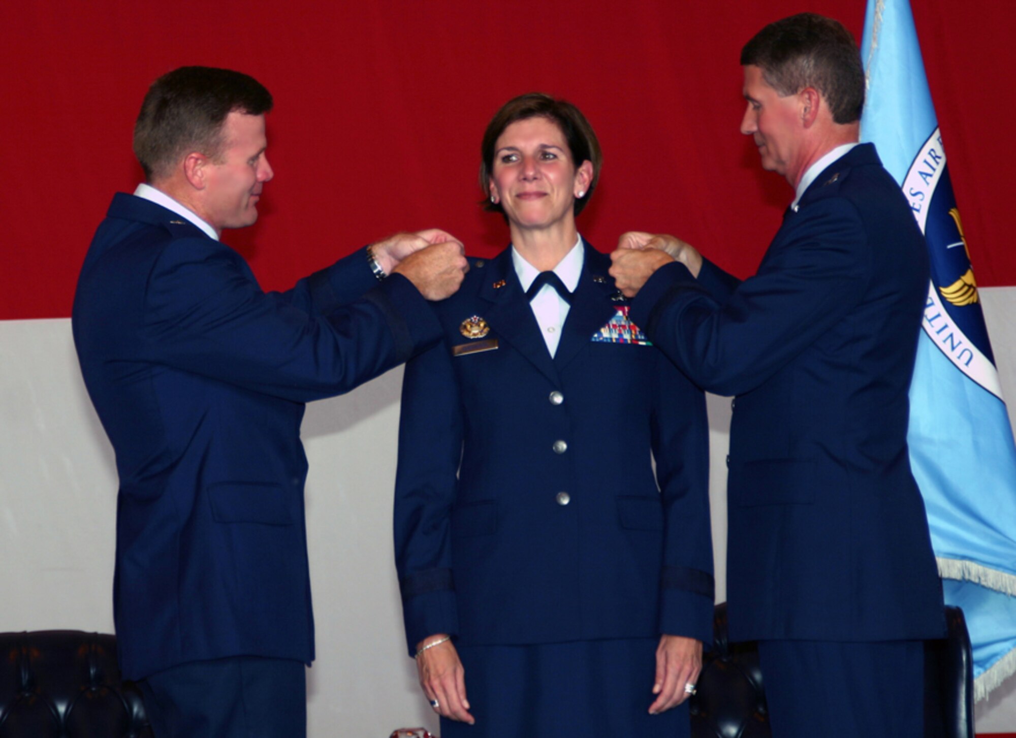 Col. Lori J. Robinson, commander of the 552nd Air Control Wing, receives her brigadier general stars pinned on by Brig. Gen. Tod Wolters (left), commander of the 325th Fighter Wing at Tyndall Air Force Base, Fla., and her husband, Maj. Gen. David Robinson, Mobilization Assistant to the Chief of the Air Force Reserves, during a brevet ceremony in Dock 2 on Sept. 21. (Photo by Senior Airman Lorraine Amaro)
