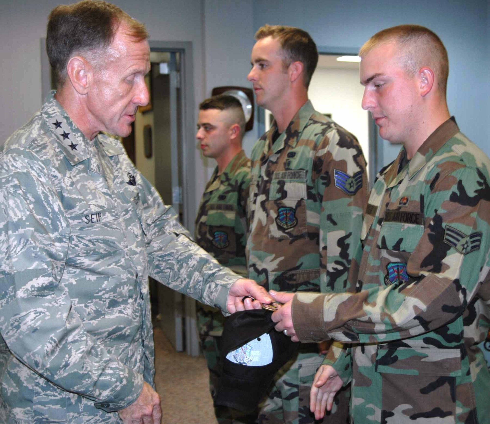 Lt. Gen. Norman Seip, 12th Air Force and Air Forces Southern commander, presents Senior Airman Travis Meyer of the 32nd Combat Communications Squadron with a coin prior to a briefing with 3rd Combat Communications Group Commander Col. James Appleyard during his Sept. 14 visit. (Air Force photo by Darren D. Heusel)
