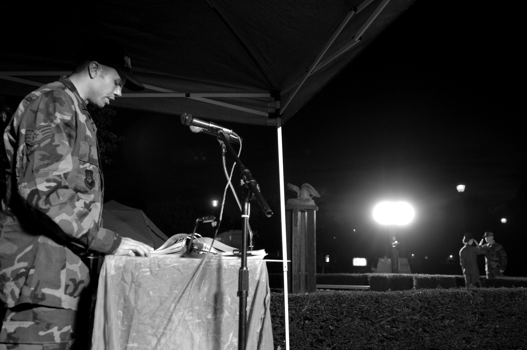 Staff Sgt. Jayton Washington, a 100th Civil Engineer Squadron Airman, reads names of military members either captured or missing in action during a 24-hour vigil at the Prisoner of War/Missing in Action memorial at RAF Mildenhall, Sept. 20, 2007. As Sergeant Washington reads, Airman 1st Class Terry Nicholas, 352nd Maintenance Squadron, salutes Senior Airman Lori Pillsbury, of the 488th Intelligence Squadron, at the POW/MIA memorial before taking over guard duty. The vigil was part of POW/MIA week, Sept. 17-21. Each volunteer read names out of one of three books for five minutes and would then replace the member standing guard at the memorial for an additional five minutes.
(U.S. Air Force photo by Tech. Sgt. Tracy L. DeMarco)

