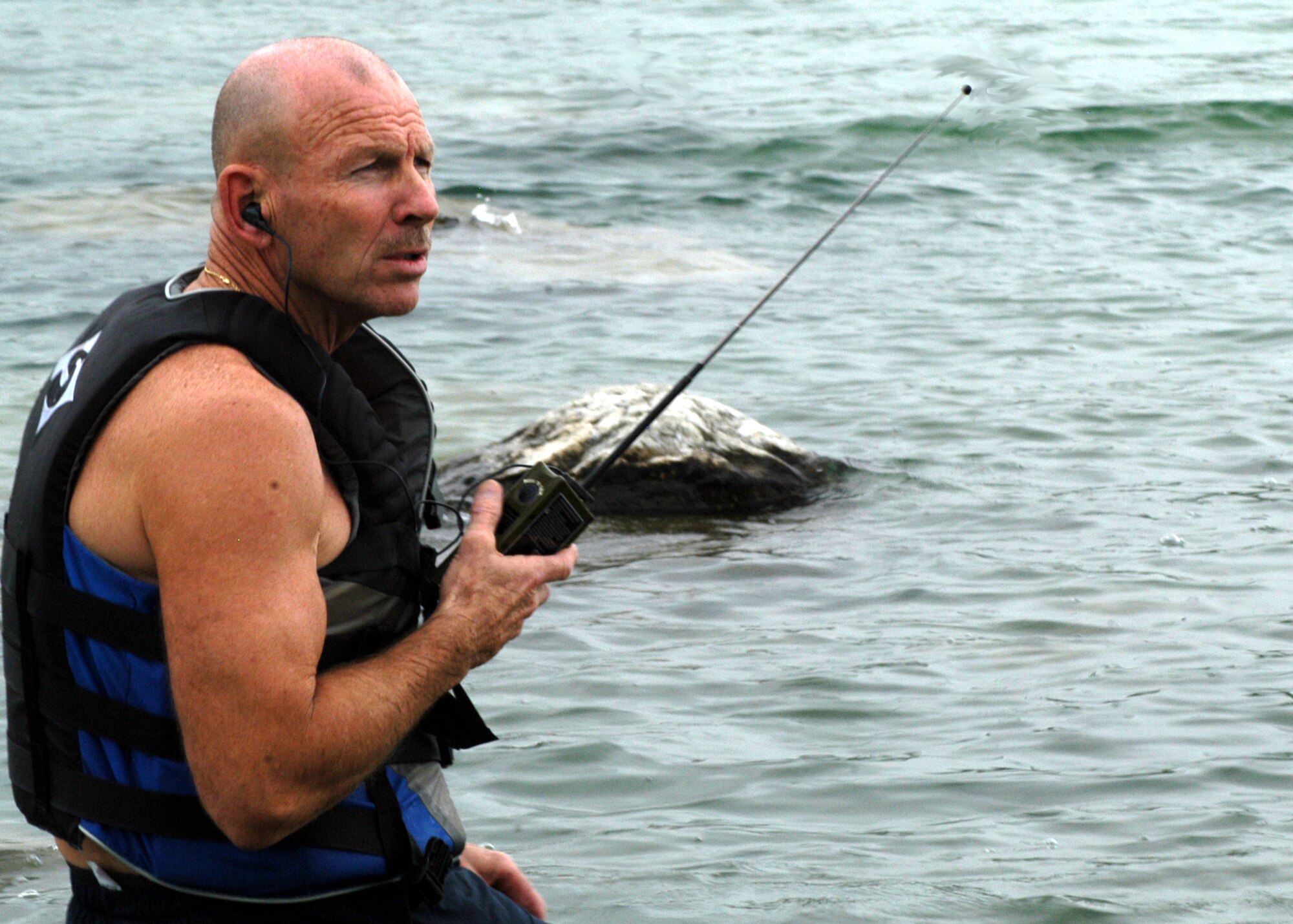 GRISSOM AIR RESERVE BASE, Ind., -- Senior Master Sgt. Dennis Hughes, 74th Air Refueling Squadron life support NCOIC, listens and looks for a Coast Guard rescue helicopter scheduled to arrive and participate in a water survival training event at a remote Cass County lake. Sergeant Hughes is a Miami County resident. (U.S. Air Force photo/Tech. Sgt. Doug Hays)