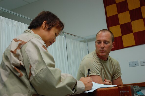 SOUTHWEST ASIA -- Maj. Edna Higa, 386th Expeditionary Medical Group clinical nurse, conducts a medical evaluation on Army patient Sgt. Scott Boomershire at the Contingency Aeromedical Staging Facility here Sept. 24.   The CASF is a 24-hour medical holding and staging facility which averages about 300 patients per month .  (U.S. Air Force photo by Staff Sgt. Tia Schroeder)
