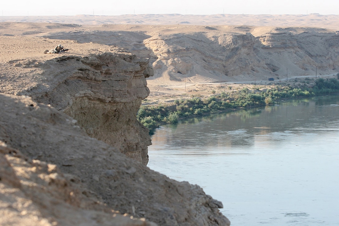 EXPEDITIONARY PATROL BASE - DULAB, Iraq, (Sept. 26, 2007) – Two Marines with Company A, 1st Battalion, 7th Marine Regiment, Regimental Combat Team 2, lay prone in an over watch position above the Euphrates River and a vehicle checkpoint on a road running parallel to the river. The VCP is part of the battalion’s strategy to counter a suspected increase of enemy activity during the Muslim holy month of Ramadan. Official Marine Corps Photo By Cpl. Ryan C. Heiser.