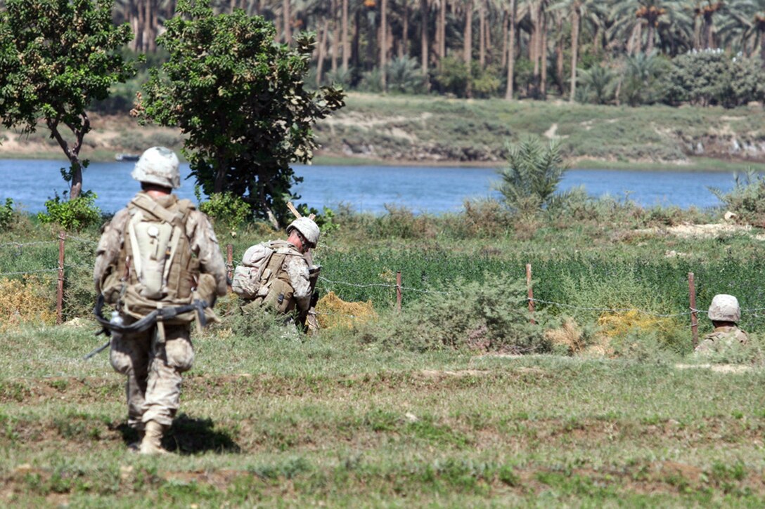 EXPEDITIONARY PATROL BASE - DULAB, Iraq, (Sept. 26, 2007) – Pfc. Joshua M. Boley, a squad automatic weapon gunner with Company A, 1st Battalion, 7th Marine Regiment, Regimental Combat Team 2, sweeps across a palm grove with the members of his fire team during Operation Bell Hurriyah. Bell Hurriyah, which means Enjoy Freedom, is battalion-wide operation directed at stopping the increase of insurgent activity during the Muslim holy month of Ramadan. Official Marine Corps Photo By Cpl. Ryan C. Heiser.