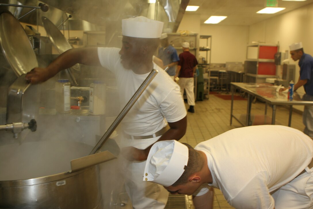 Cpl. Julio A. Aguayo, Headquarters and Support Company, 3rd Battalion, 4th Marine Regiment, and Lance Cpl. Darnell F. Garrett, Headquarters and Support Company, Marine All-Weather Fighter Attack Squadron 224, boil vegetables for the afternoon meal at the Combat Center's Phelps Hall Sept. 26.