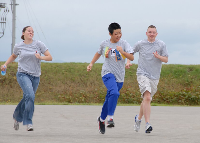 MISAWA AIR BASE, Japan --Airmen 1st Class Tara Smith and Staff Sgt Jesse Daughtry, from the 35th Logistics Readiness Squadron, run alongside 16 year old Hiroki Kanbe from the Mominoke-Gakuen school during the 2007 Special Olympics here Sept. 22. The Special Olympics are held annually to promote relations between the American forces serving in Japan and the surrounding community.  (U.S. Air Force photo by Senior Airman Laura R. McFarlane)


