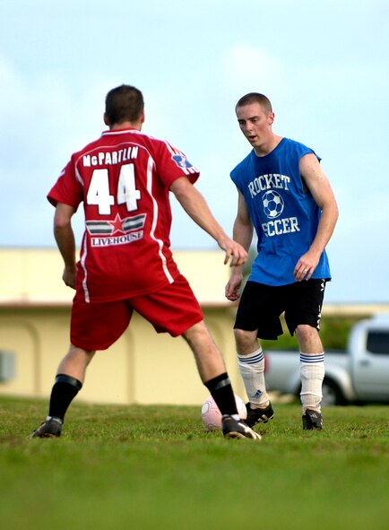 Senior Airman Brian Kimball, 36th Communications Squadron, attempts to dribble the ball past his opponent from the 36th Civil Engineering Squadron during their intramural soccer game, Sept. 25.  The 36th CES won the game against the 36th CS with a resulting score of 8-1.  (U.S. Air Force photo/Senior Airman Miranda Moorer)                