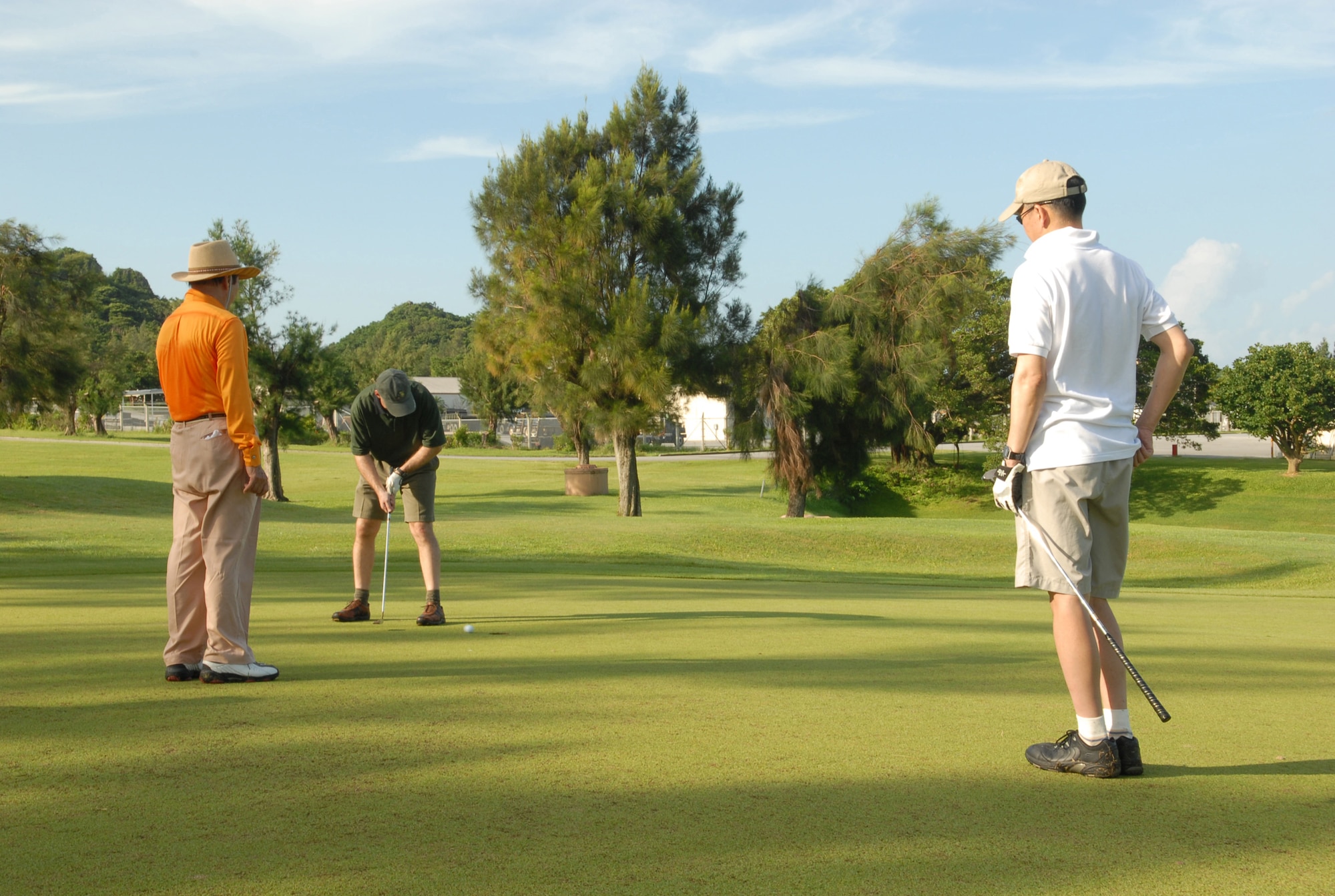 Col. Manson Morris putts on the green at Kadena Air Base, Japan, Sept. 24, 2007, with his two of his foursome,  Mr. Kosei Nakamoto, vice chairman of the Okinawa Chamber of Commerce and Rear Admiral Kenji Noi from the Japanese Maritime Self Defense Force.  All were playing golf as part of the base's Annual Friendship Golf Tournament where U.S. and Japanese military and community leaders gather for golf and camaraderie . Colonel Morris is the 18th Wing vice commander.  (U.S. Air Force photo/Junko Kinjo)