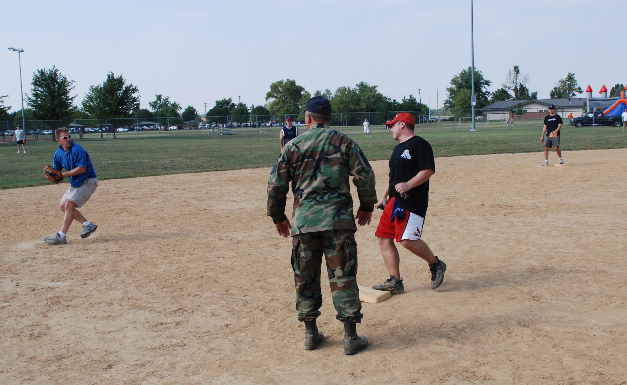 An officer of the 932nd Airlift Wing prepares to throw out the runner at the recent softball match.