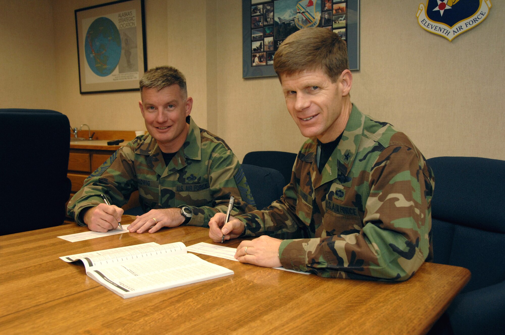 EIELSON AIR FORCE BASE, Alaska -- Brig. Gen. Mark Graper, 354th Fighter Wing commander, and Chief Master Sgt. Stephen Ludwig, 354th Fighter Wing command chief, sign their individual pledges for the Combined Federal Campaign  Sept. 25. 2007 at Amber Hall. CFC is the world?s largest and most successful annual workplace charity campaign. Pledges made by Federal civilian, postal and military donors during the campaign season (Sept. 1 - Dec. 15) support eligible non?profit organizations that provide health and human service benefits throughout the world. Last year Eielson raised $95,106 for the CFC and this year's goal is set at $95,000.  (U.S. Air Force photo by Airman 1st Class Christopher Griffin)