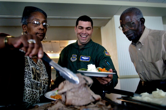 Master Sgt. Justin Strain, 14th Airlift Squadron, holds a plate for former prisoner of war Jacob Scott from Charleston, S.C., Sept. 21 during a lunch at the Charleston Club honoring comrades who are missing in action and have been prisoners of war. (U.S. Air Force photo/Airman 1st Class Nicholas Pilch)