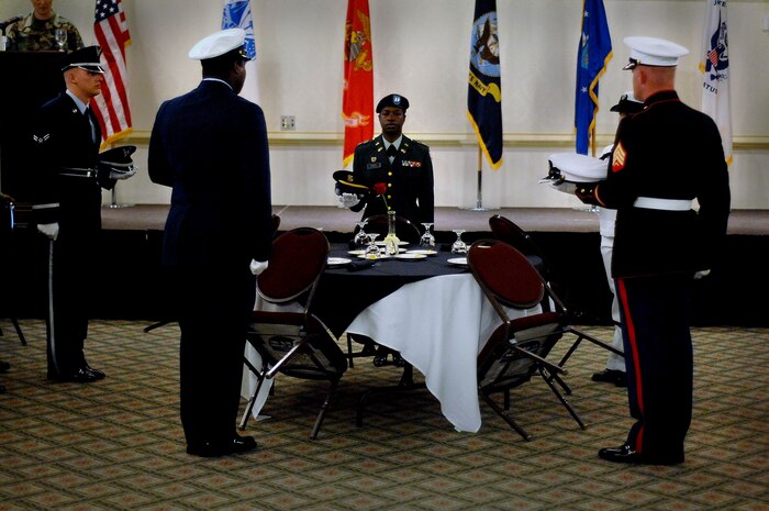 Members from each branch of the military place a cap from each branch on the missing in action and prisoners of war table during lunch Sept. 21 at the Charleston Club. (U.S. Air Force Photo/Airmen 1st Class Nicholas Pilch)