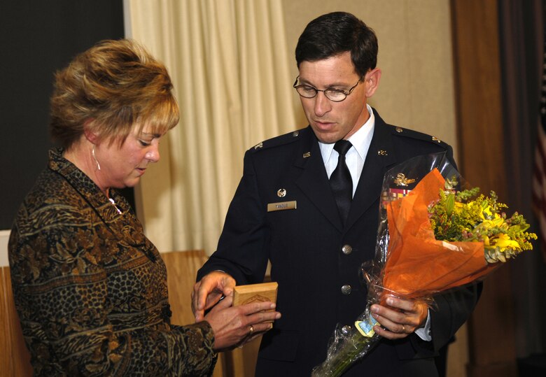 VANDENBERG AIR FORCE BASE, Calif.-- Guest speaker Mrs. Carol Ray of Orcutt, Calif., whose father, Col. Hubert Nichols, Jr., was listed as a POW/MIA for nearly twelve years during the Vietnam War, receives a commemorative 30th Space Wing coin and flowers from Col. Steve Tanous, 30th Space Wing commander, for speaking at the POW/MIA Ceremony on Sep. 21. Vandenberg gathered for the remembrance ceremony to honor fallen Airmen, Soldiers, Seamen and Marines.  (U.S. Air Force photo by Airman 1st Class Cole Presley) 