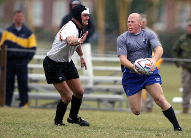 Senior Airman James Hubby, 437th Comptroller Squadron and member of the Air Force rugby team, dodges a Marine during the 2006 Armed Forces Rugby Championship at Camp Lejeune, N.C. (U.S. Air Force photo/Maj. Scott Foley)