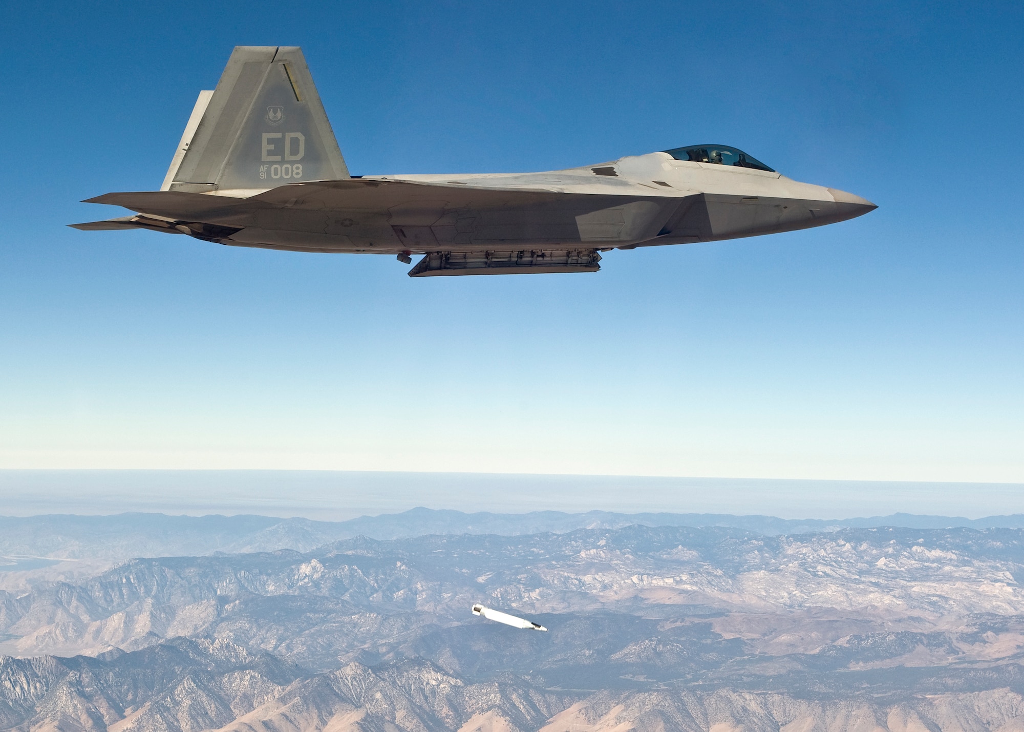 An F-22 Raptor drops a small diameter bomb from its weapons bay during a test mission Sept. 5. The test marks the first airborne separation of a small diameter bomb from the internal weapons bay of an F-22. (Photo by Darin Russell)