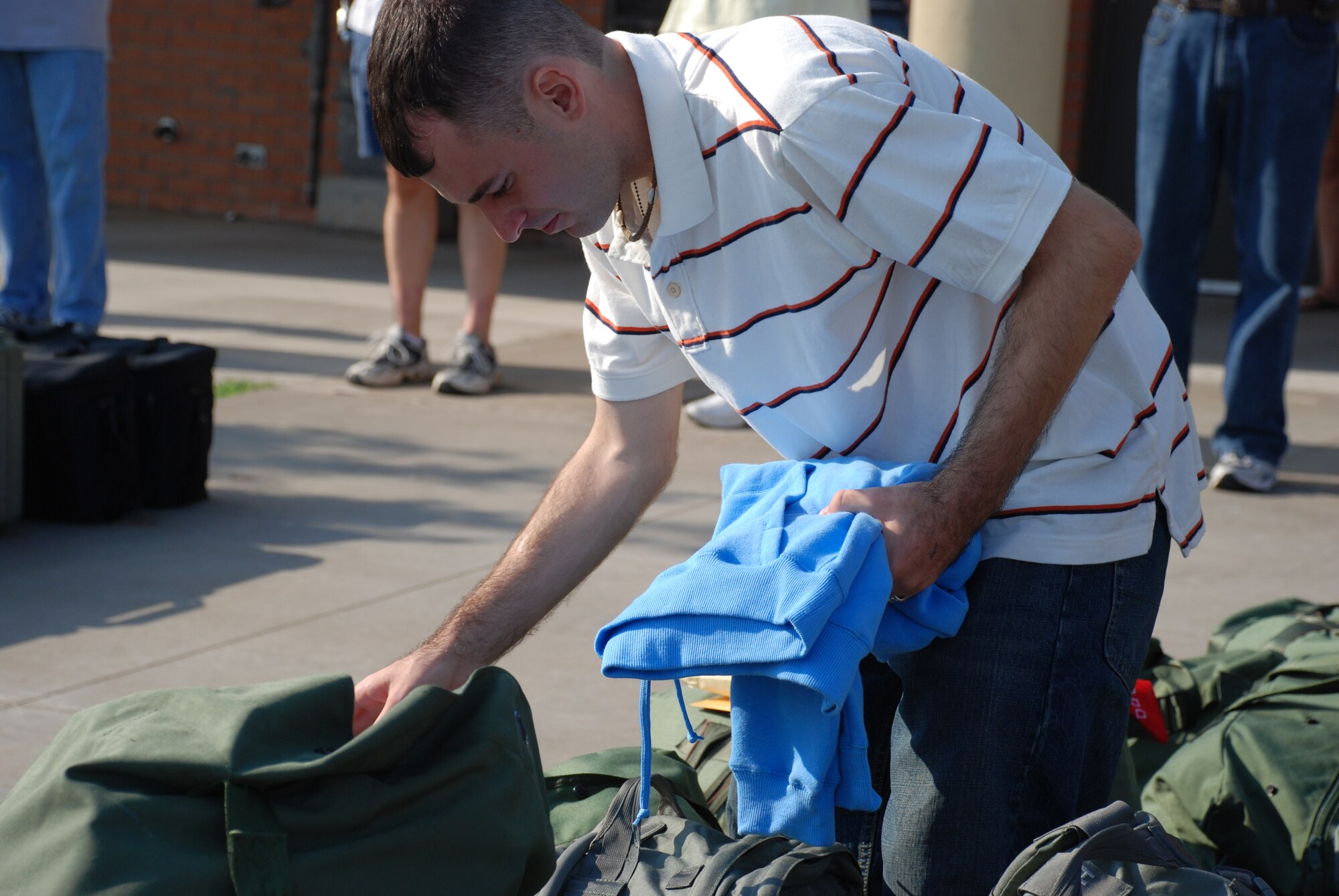Airman 1st Class William Landrum makes some last-minute adjustments to his duffle bag Sept. 23 before he and 12 of his 82nd Security Forces Squadron teammates board a bus for Dallas/Fort Worth International Airport. The 13-man team flew to Fort Lewis, Wash., for additional training with the Army before they head overseas. (U.S. Air Force photo/John Ingle)