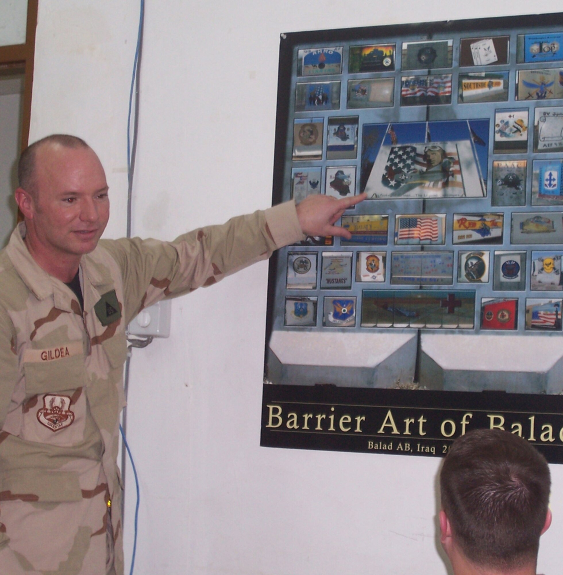 Mr. Gildea explains the historical significance of the Tuskegee Airmen wall at Balad to Capt. David Mays, 81st Security Forces Squadron, who was also deployed.  (Courtesy photo)