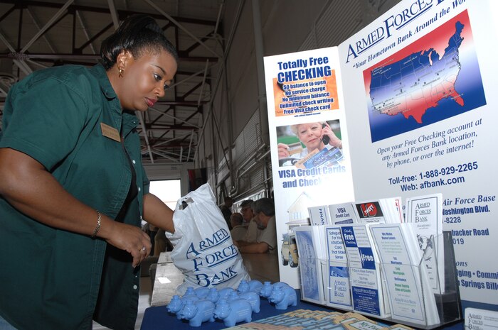 Mrs. Rina Brown, Armed Force Bank branch manager, sets up an informational booth during the annual Nellis Retiree Appreciation Day, Sept. 22. The event, held to recognize and honor military retirees, attracted approximately 800 prior servicemembers. (U.S. Air Force photo by Airman 1st Class Brian M. Ybarbo)