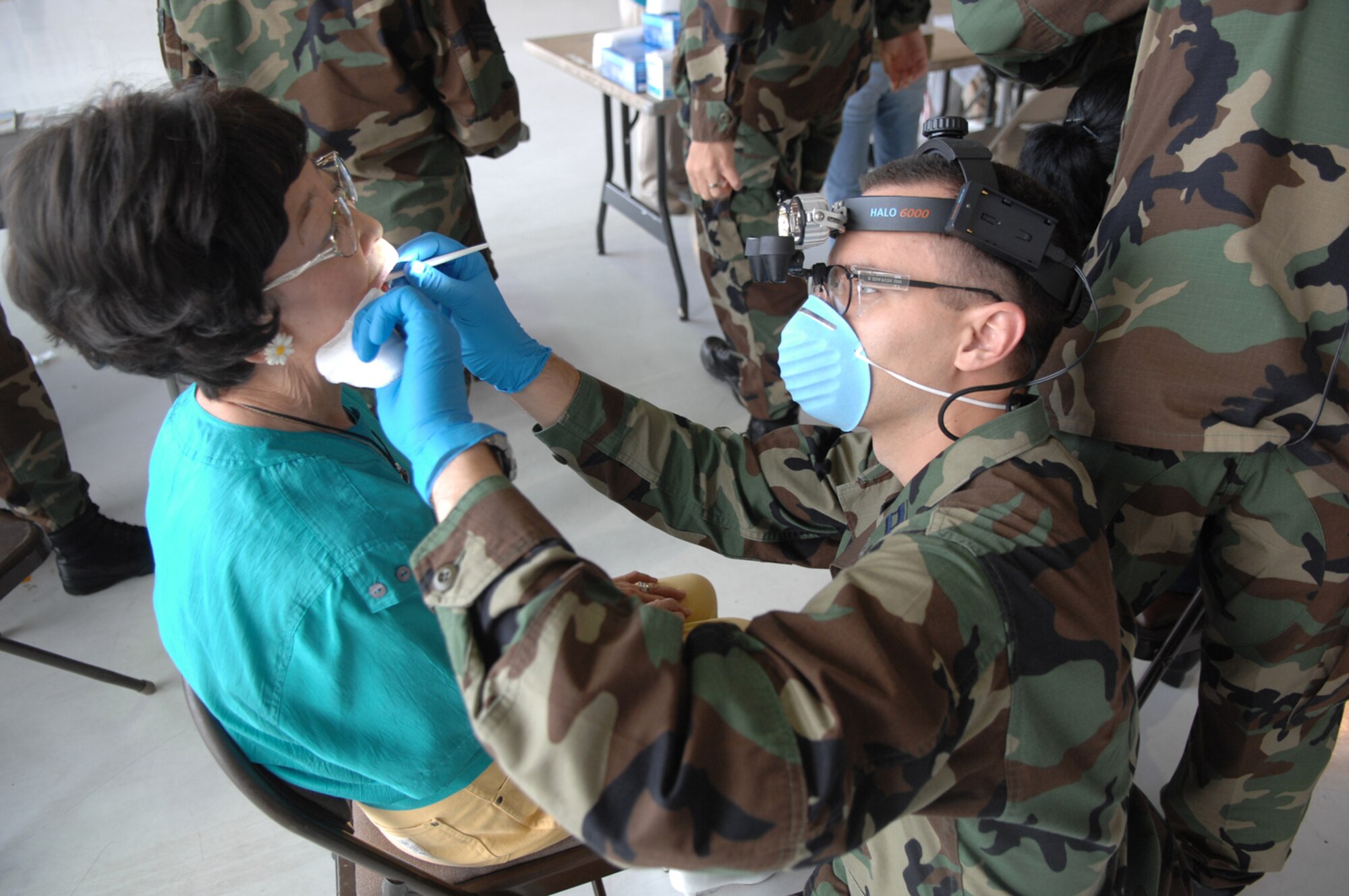 Captain Nicholas Marcus, 99th Dental Squadron, performs an oral cancer screening on Katsura Willson, retiree dependent, during the annual Nellis Retiree Appreciation Day, Sept. 22.  The event, held to recognize and honor military retirees, attracted approximately 800 prior servicemembers. (U.S. Air Force photo by Airman 1st Class Brian M. Ybarbo)