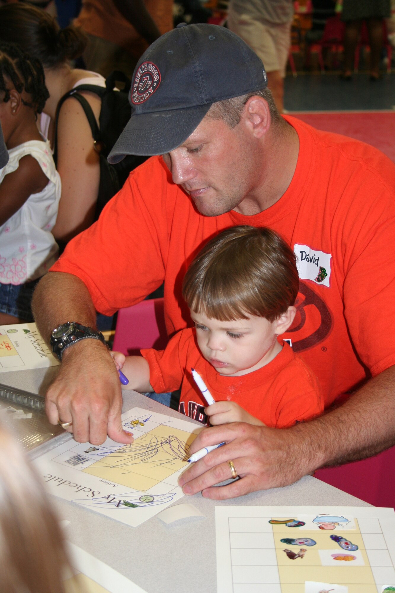 The Whitson's make an daily schedule using stickers and markers at the Tell Me a Story event on Sept. 22, 2007 at Eglin Air Force Base Youth Center. The event sponsered in part by the Miltary Child Education Coalition, and teaches parents and children to use everyday items to improve motor skills. (U.S. photo by Senior Airman Ali E. Flisek)