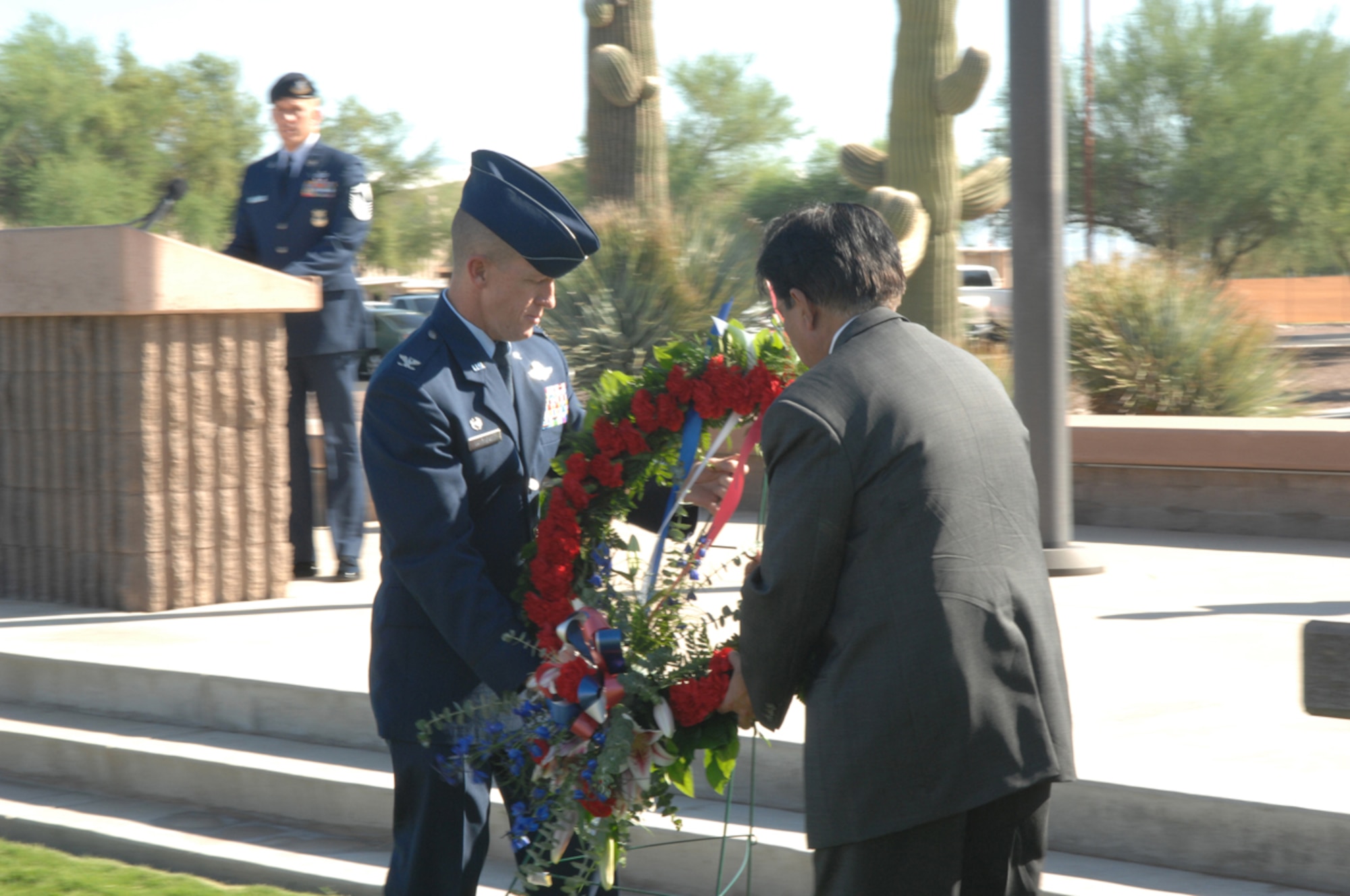 355th Fighter Wing Commander Col. Kent Laugbaum and Dr. Jayendra Shah, Chief of Staff, Southern Arizona Veteran Affairs Health Care System place a memorial wreath at the base of the flagpole during the Prisoner of War/Missing in Action Recognition Day Ceremony held at Davis-Monthan Sept. 21.  (U.S.Air Force photo by A1C Alesia Goosic)