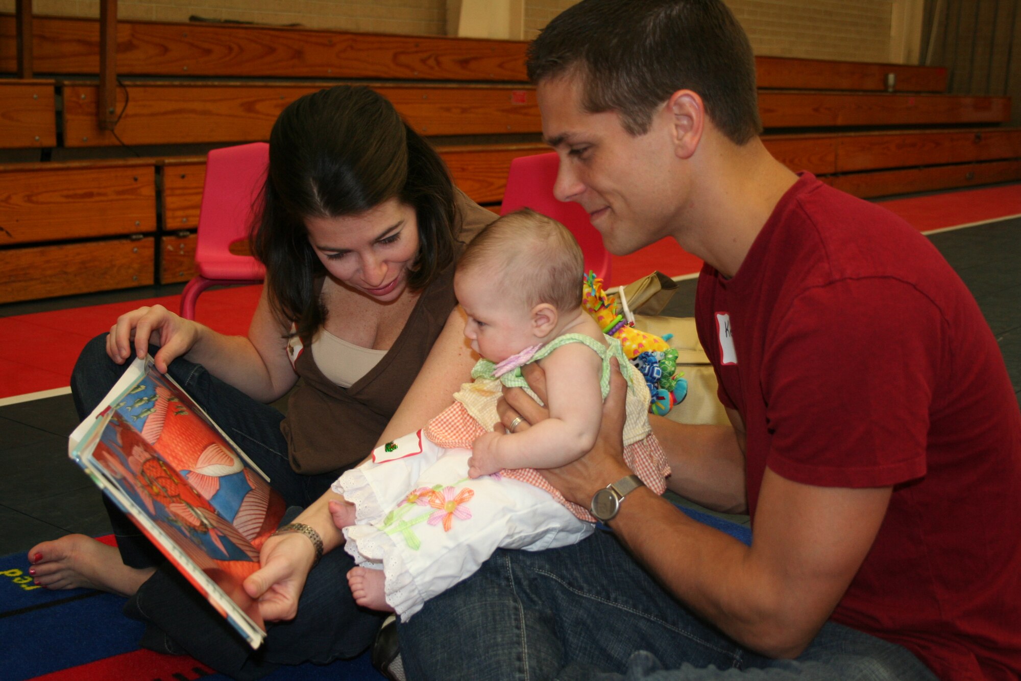 The Corso's look through a picture book with thier three month old daughter, Stella during the Tell Me a Story kick off event on Sept. 22, 23007 at Eglin Air Force Base Youth Center. The event encouraged military children, ages 0-4 to use thier imaginations. (U.S. photo by Senior Airman Ali E. Flisek)