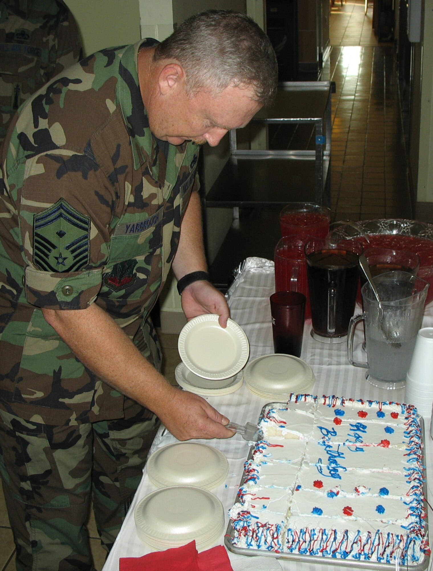 DYESS AIR FORCE BASE, Texas -- Senior Master Sgt. Will Yarbrough, 7th Operations Group first sergeant, helps himself to a generous slice of birthday cake while attending the Longhorn Dining Facility's birthday meal for third-quarter dormitory residents' birthdays Sept. 20. (Courtesy photo)
