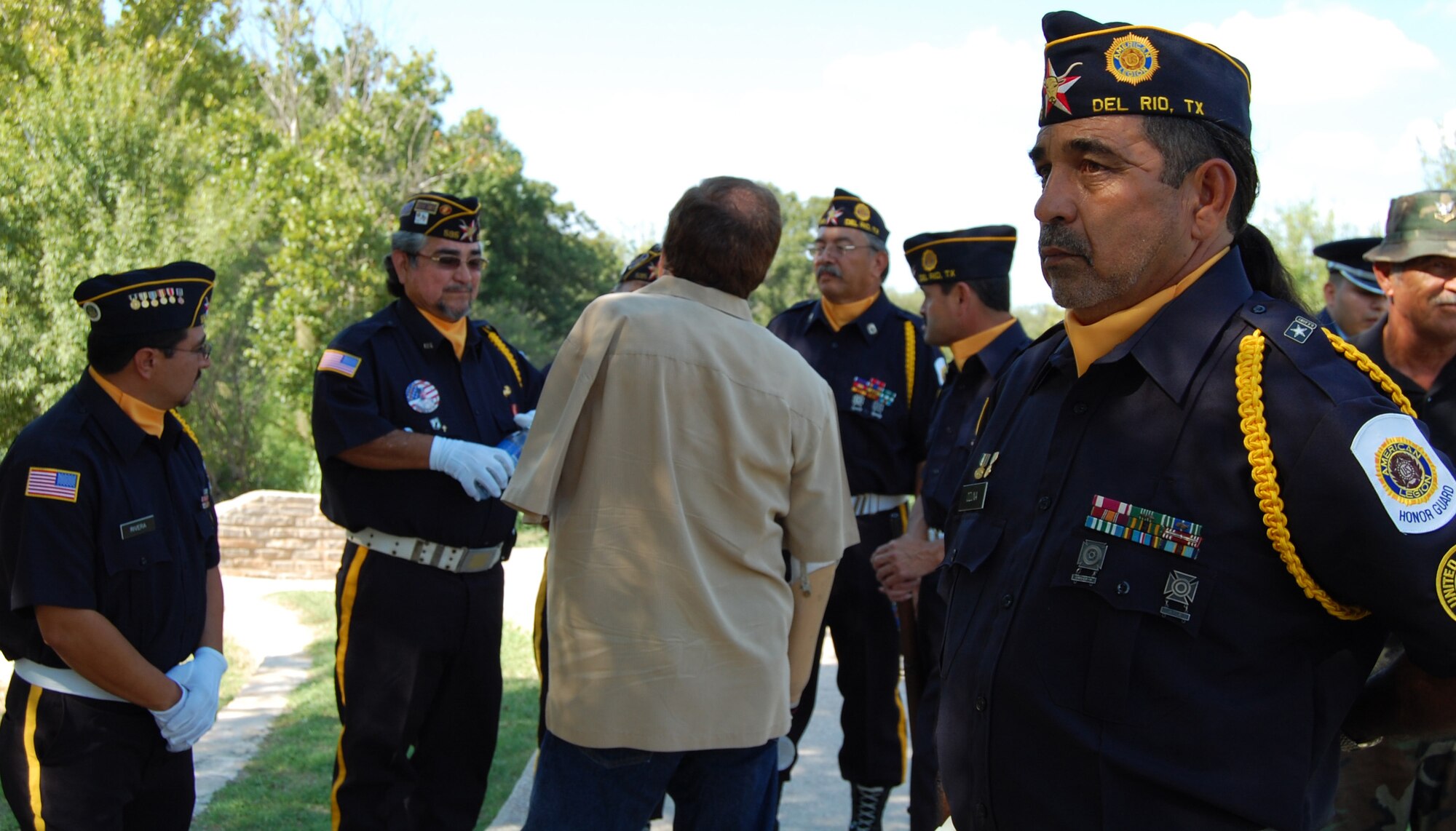 LAUGHLIN AIR FORCE BASE, Texas – Oscar Ozuna, commander of the Jesus m. Limones Jr. American Legion Post 595 Honor Guard and Laughlin’s Recycling Center project manager, awaits the ceremony for National POW/MIA Recognition Day at the Dr. Alfredo Gutierrez Jr. Amphitheatre, Del Rio, Texas, while fellow honor guard members talk with war veterans. (U.S. Air Force photo by Airman Sara Csurilla) 