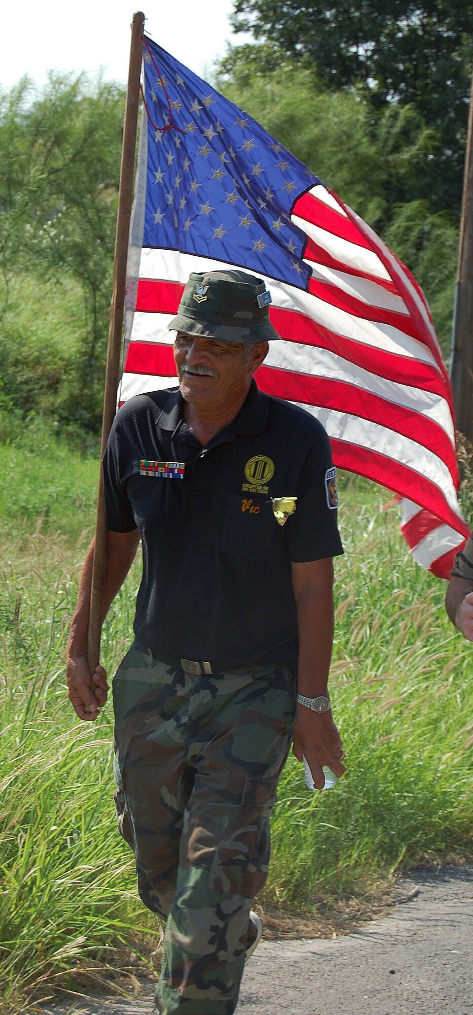 LAUGHLIN AIR FORCE BASE, Texas – Vick Meza, Vietnam Veteran and Del Rio, Texas resident, carries the American Flag proudly as he nears the end of a motivating walk for National POW/MIA Recognition Day Sept. 21. (U.S. Air Force photo by Airman Sara Csurilla)