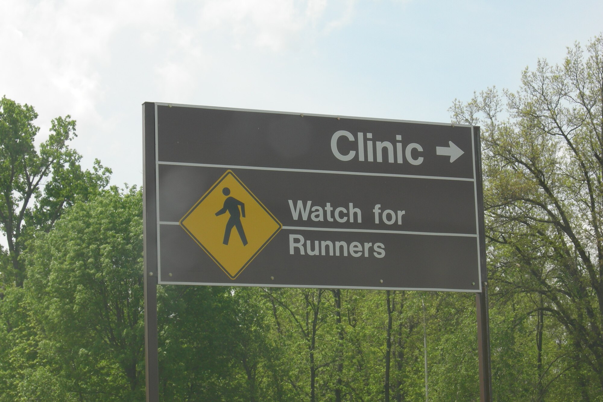 A posted sign near the base track reminds motorists to be vigilant of runners. Where sidewalks are not provided, pedestrians walking or jogging along the roadway shall, when practicable, do so only on the left side of the road, at its shoulder, facing traffic. Joggers will wear light colored/reflective clothing during hours of darkness. (Photo printed with permission of Tech. Sgt. Raul Betancourt)

