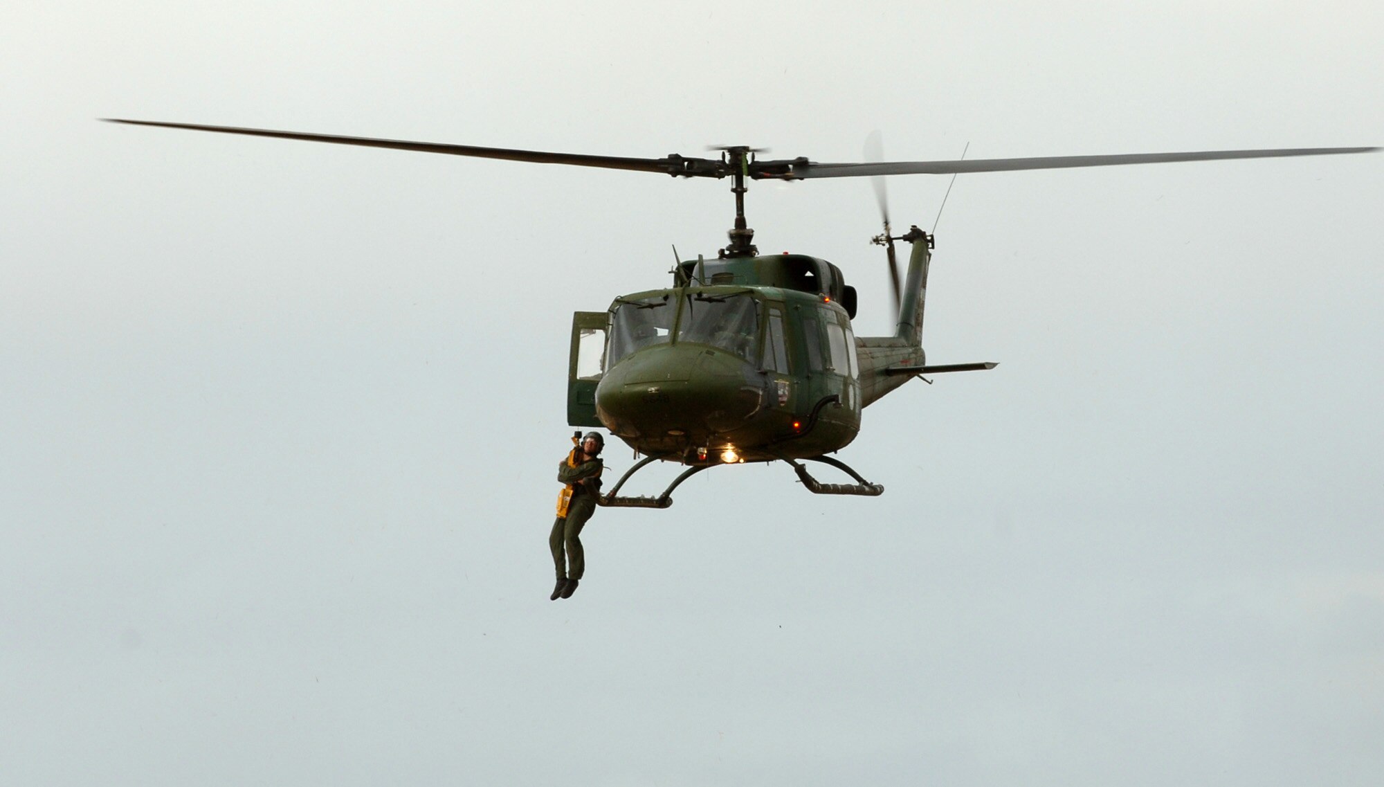 Senior Airman Brian Daubert is hoisted into a helicopter during a combat search and rescue demonstration Sept. 18 at Fairchild Air Force Base, Wash. Weekly demonstrations give students a chance to see firsthand the techniques they've learned in the SERE classroom, such as using the parachute descent checklist. Airman Daubert is a survival, evasion, resistance and escape specialist here. (U.S. Air Force photo/Airman 1st Class Jocelyn Ford)