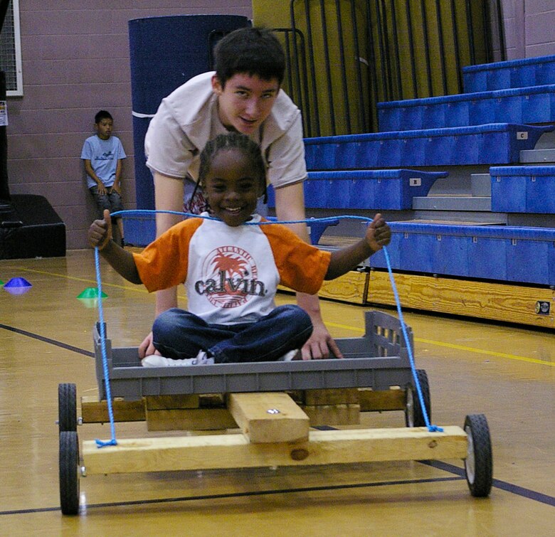 Julius Pullen, 4, tries his hand at carting, with the help of Jordan Strickland, at the youth center Sept. 15 during the Day for Kids event. (U.S. Air Force photo by Karen Abeyasekere)