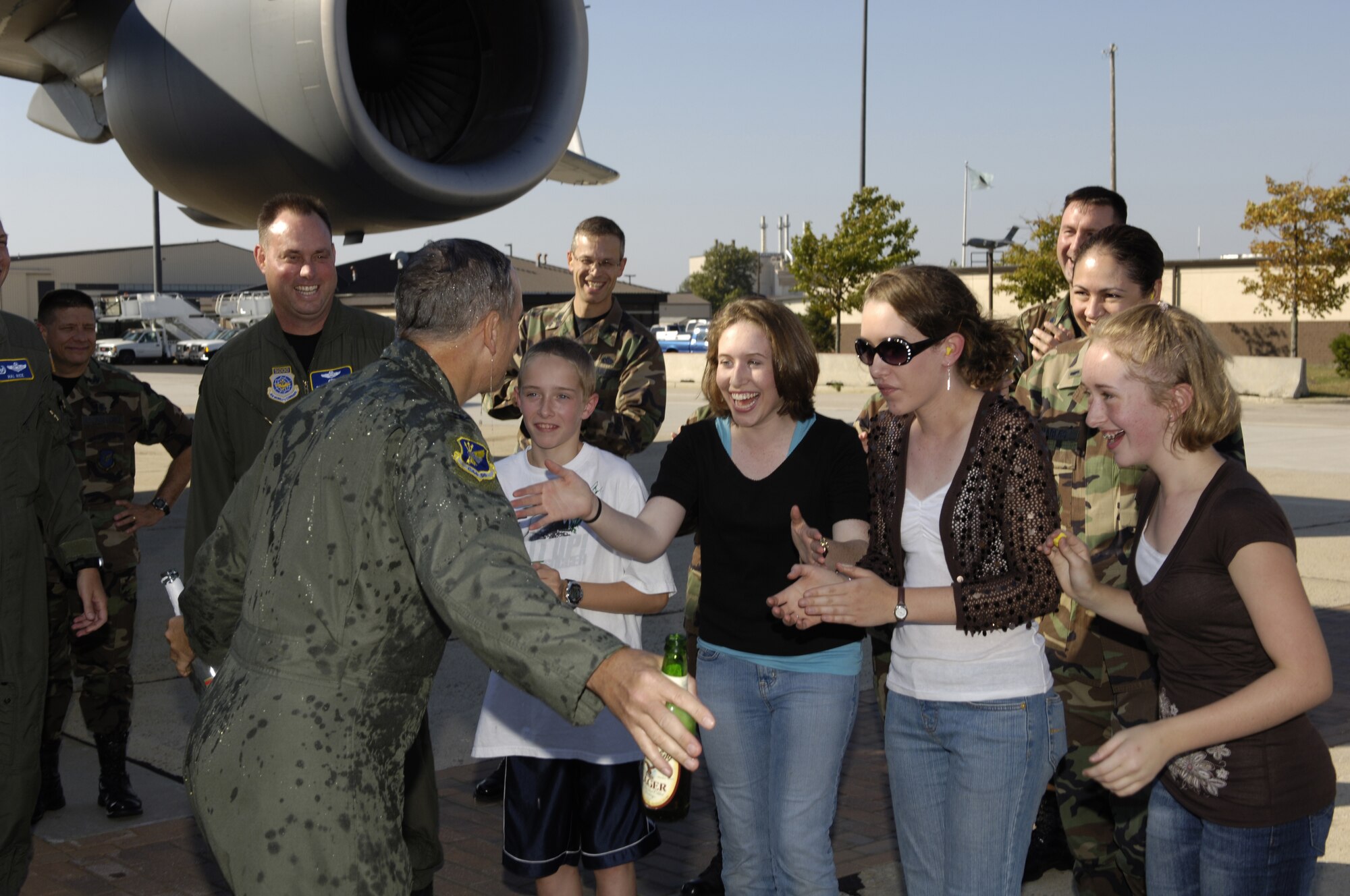 Col. Rick Martin, 305th Air Mobility Wing commander, hugs his family after he was given the traditional "hosing down" following his fini-flights on a KC-10 and C-17. (U.S. Air Force photo/Kenn Mann)
