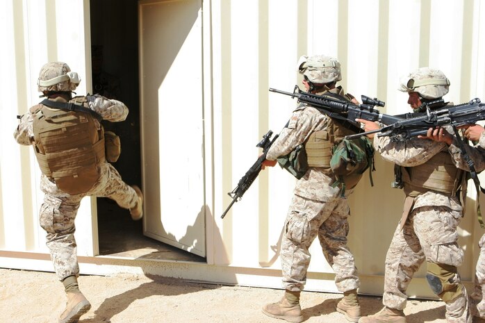 Lance Cpl. David L. Negrete, a rifleman with Echo Company, 2/24, kicks in a door at Combat Center Range 225 so his fellow Marines can clear the house Sept. 27.