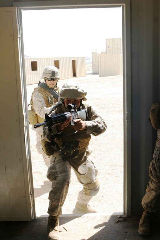 Lance Cpl. Keith Ulrich, a machine gunner with Echo Company, 2/24, and Lance Cpl. Truc. T. Nguyen, a rifleman with Echo Company, 2/24, clear a house at Combat Center Range 225 Sept. 27.