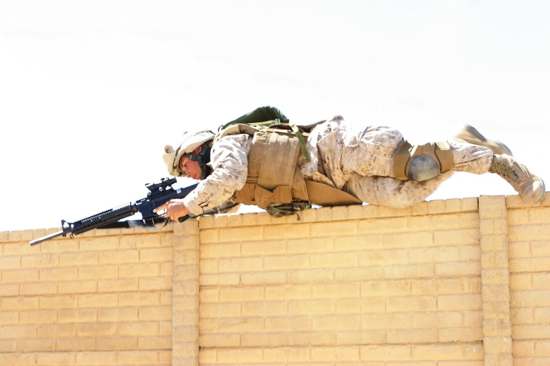 Lance Cpl. Keith Ulrich, a machine gunner with Echo Company, 2/24, scales a wall at Combat Center Range 225 Sept. 27.