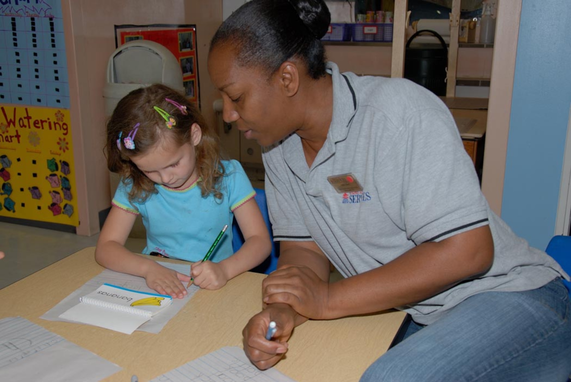 MISAWA AIR BASE, Japan -- Celia Clark, child development center provider, works with Alyssa, daughter of Tech. Sgt. Donald and Windy Torgerson, on her writing at the main bases CDC here. (U.S. Air Force photo by Senior Airman Laura R. McFarlane)