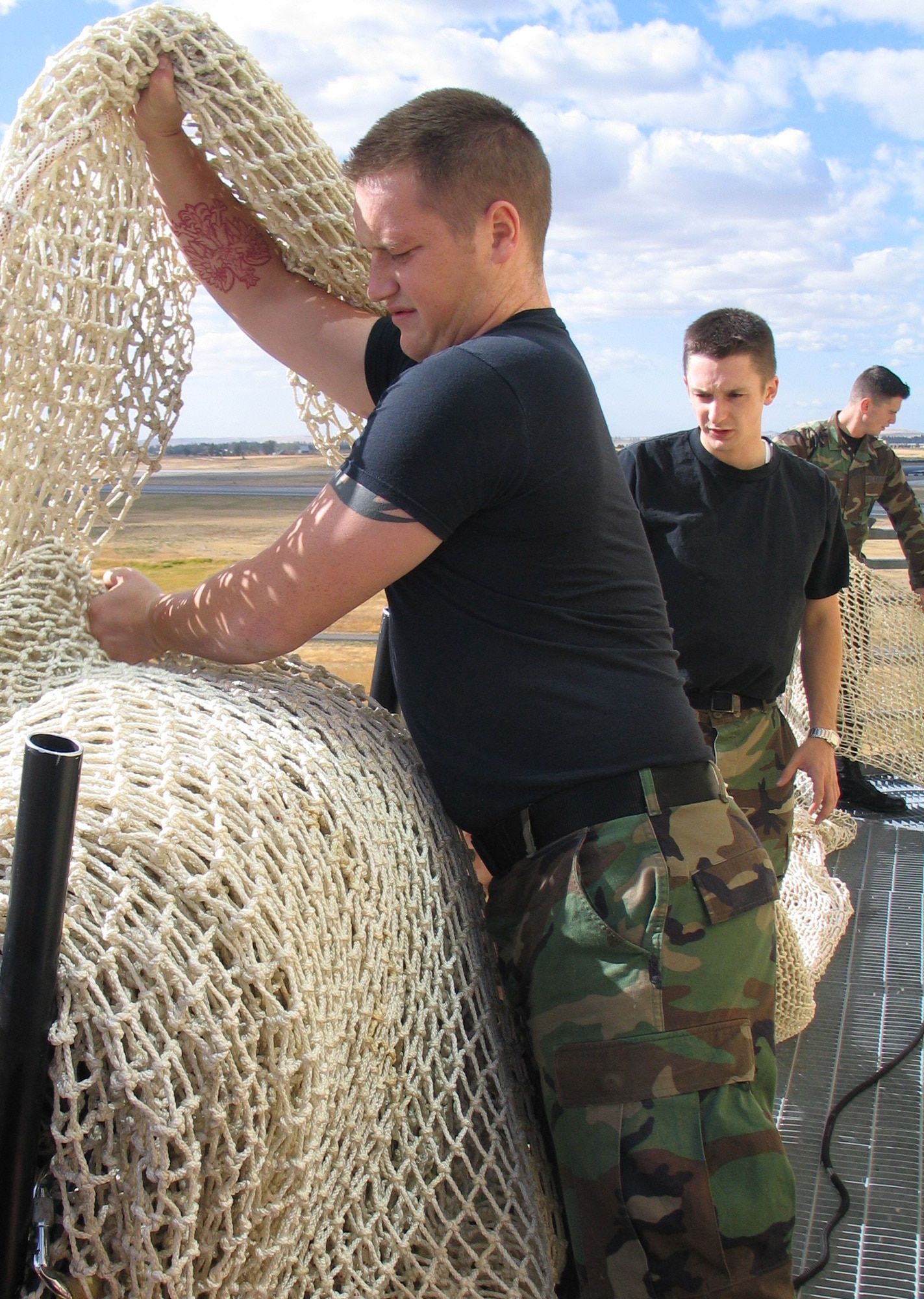 FAIRCHILD AIR FORCE BASE, Wash. – With the assistance of fellow air traffic control crew members, Airman 1st Class Kyle Sweiderk, 92nd Operations Support Squadron air traffic controller, neatly folds the Baker’s Life Chute, an emergency evacuation apparatus, after a day of training on the use of the chute. (U.S. Air Force photo / Airman 1st Class Kali L. Gradishar)