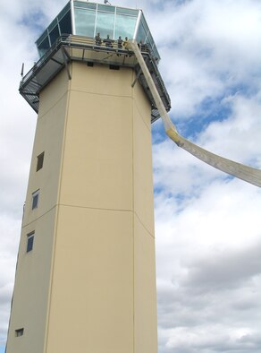 FAIRCHILD AIR FORCE BASE, Wash. – On the catwalk of the air traffic control tower, Airmen watch as Chief Master Sgt. Paul Sikora, command chief, plunges down the Baker’s Life Chute. The chute is used in cases of extreme emergency when the air traffic control group must evacuate the tower immediately. (U.S. Air Force photo / Airman 1st Class Kali L. Gradishar)