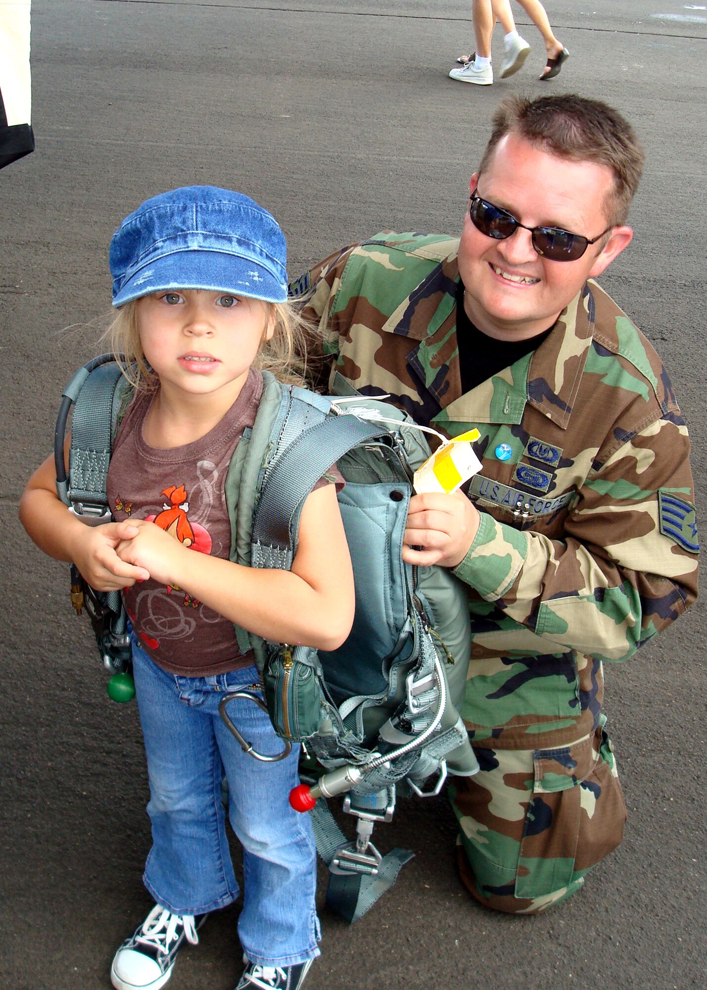 Air Force Reservist Staff Sgt. Michael Drope, 314th Aircrew Life Support technician, shows Tatiana Meister, 5 years old, how to wear a parachute during the Reno Air Races and Air Show Sept. 15, 2007 in Reno, Nev. Sergeant Drope came with a KC-135R Stratotanker and other Reservists from the 940th Air Refueling Wing at Beale Air Force Base, Calif. to help educate the public about the Air Force mission and the Air Force Reserve.  (Courtesy photo/Holly A. Meister)             