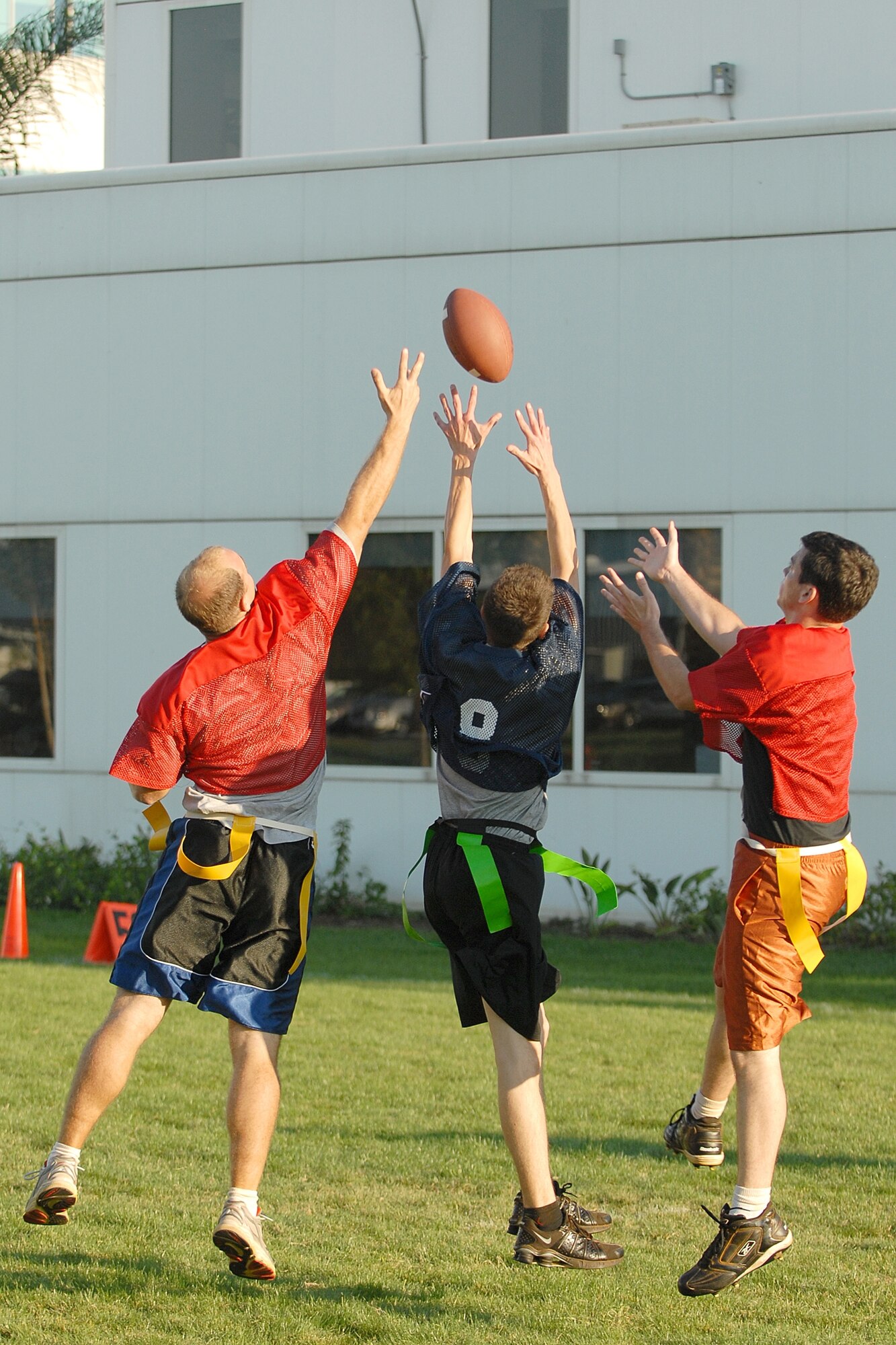 Senior Airman Jacob Clark (middle) attempts to receive a pass and while battling for control of the ball with Capt. Neil Moser and 1st Lt. Adam Young during a flag football game between the 61st Medical Group and Launch and Range Systems Wing, Sept. 25. The 61st Medical Group won 20 to19. (Photo by Stephen Schester)