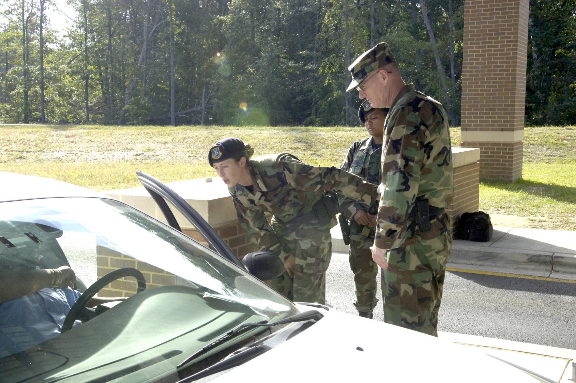 Col. Paul Ackerley, 316th Wing commander, Staff Sgt. Raven Coulon and Senior Airman Vanessa Agcamaran, 316th Security Forces Squadron Security Response Team members, work at the Main Gate checking Identifications cards during early morning hours Sept. 20. Colonel Ackerley also patrolled the base in a security forces vehicle, met with flightline security details and observed operations from the Pathfinder Control Center, while spending time with the 316th Security Forces Squadron.
