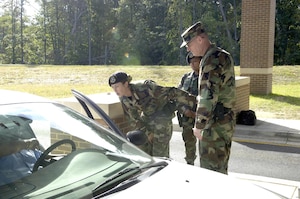 Col. Paul Ackerley, 316th Wing commander, Staff Sgt. Raven Coulon and Senior Airman Vanessa Agcamaran, 316th Security Forces Squadron Security Response Team members, work at the Main Gate checking Identifications cards during early morning hours Sept. 20. Colonel Ackerley also patrolled the base in a security forces vehicle, met with flightline security details and observed operations from the Pathfinder Control Center, while spending time with the 316th Security Forces Squadron.