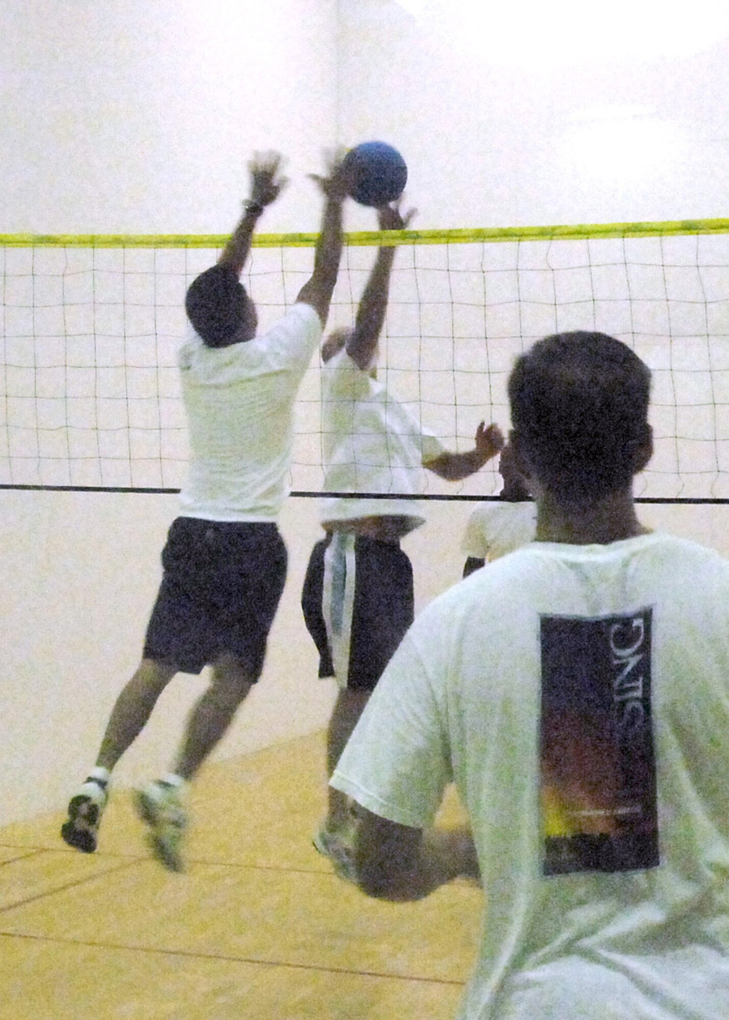 Col. Steve Beatty, 61st Air Base Wing vice commander and Master Sgt Rico Pamintuan, 61st Communications Squadron,  jump for the ball, while Chaplain Brad Kimble looks on during a walleyball game at the Los Angeles AFB Fitness Center, Sept. 19.  Played on a racquetball court, walleyball is similar to volleyball.  Sponsored by the Chaplain’s Office, the base community is invited to join in the play every Wednesday from 7 to 8:30 a.m.  (Photo by Lou Hernandez)