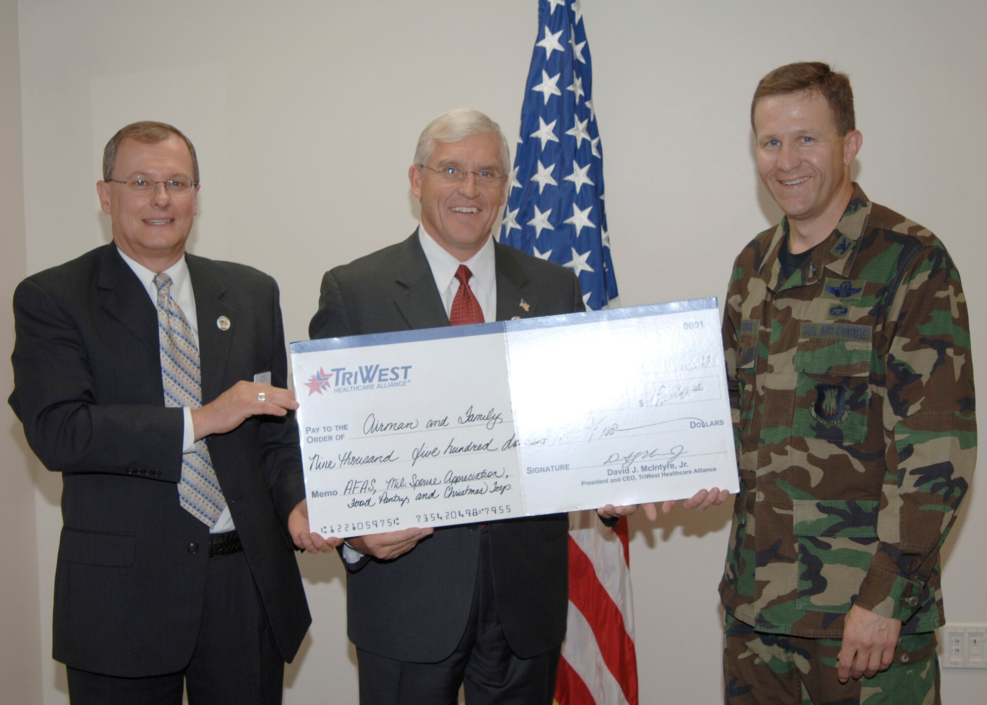 MCCONNELL AIR FORCE BASE, Kan. -- Tim Ray, left and Don Brown, TRIWEST Health Care Alliance Representatives present Col. John Zazworsky, acting 22nd Air Refueling Wing Commander with a check for the Airman and Family Readiness Center, family program and Air Force Aid Society, Sept 20. Since 2005 TRIWEST has donated $28,500 to McConnell. (photo by Airman 1st Class Roy Lynch III) 