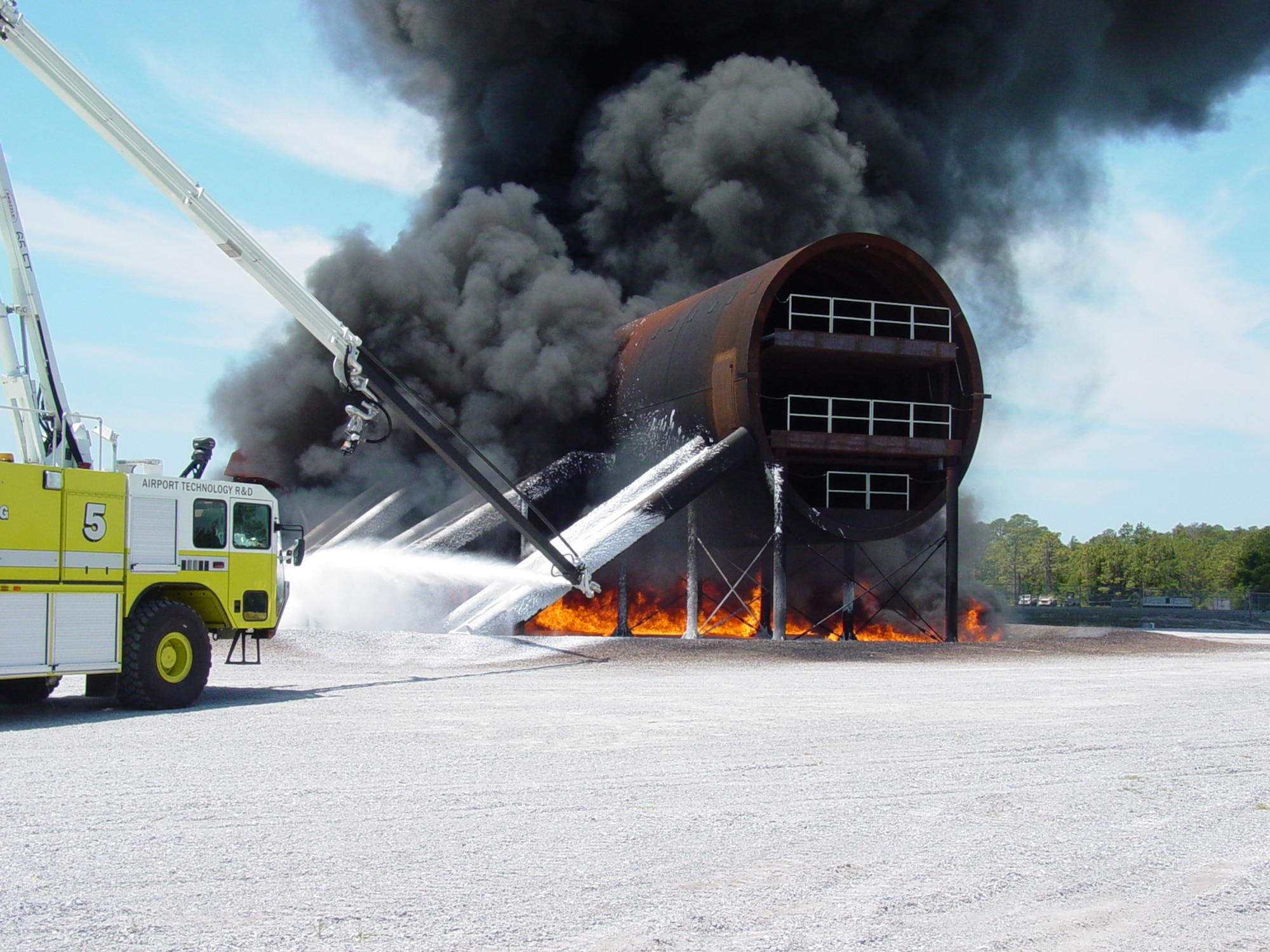 Engineers conduct a JP-8 pool fire using 250 gallons of fuel to test temperature sensors on the New Large Aircraft mockup at Tyndall Air Force Base.  Air Force Research Laboratory, working with the FAA, developed the mockup to research firefighting and rescue techniques in today's larger, multi-deck aircraft. (U.S. Air Force)