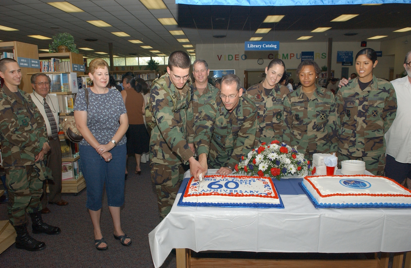 Col. Bob LaBrutta, 37th Mission Support Group commander, cuts a cake with Airman Basic Zachary Bruhn, 342nd Training Squadron, at the Lackland Base Library Sept. 17, 2007. The cake-cutting ceremony officially ended the week of festivities held in honor of the service's birthday. (USAF photo by Alan Boedeker)                                