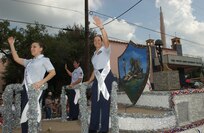Randolph Air Force Base Ambassador 1st Lt. Jennifer Ferrer, left, Brooks City-Base Ambassador Master Sgt. Yvonne Terry, center, and Lackland AFB Ambassador Tech. Sgt. Magdalena Cortez wave to crowds while riding a float downtown at the 26th Annual Guadalupe Street Parade Sept. 15. The parade was part of San Antonio's Diez y Seis de Septiembre festivities, which celebrate Mexico's independence from Spain on Sept.16, 1810. An estimated 2,500 spectators gathered along Guadalupe Street for the event. (USAF photo by Alan Boedeker)